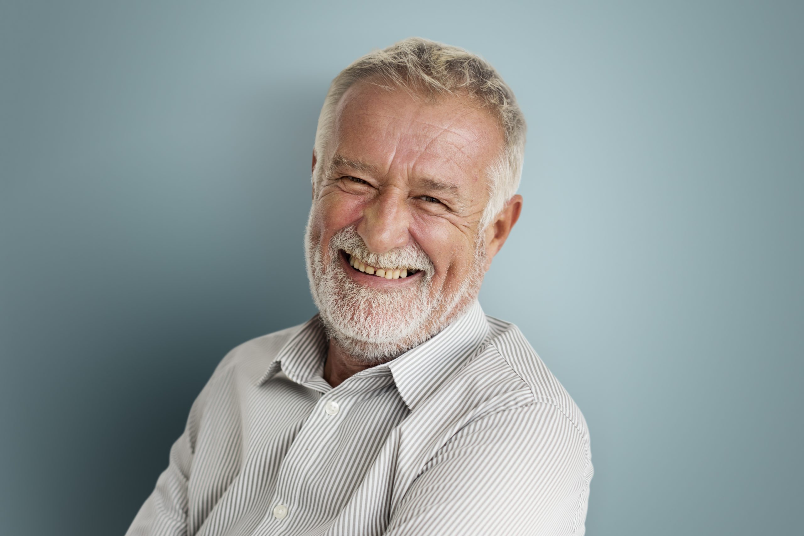 An elderly man smiling at the camera