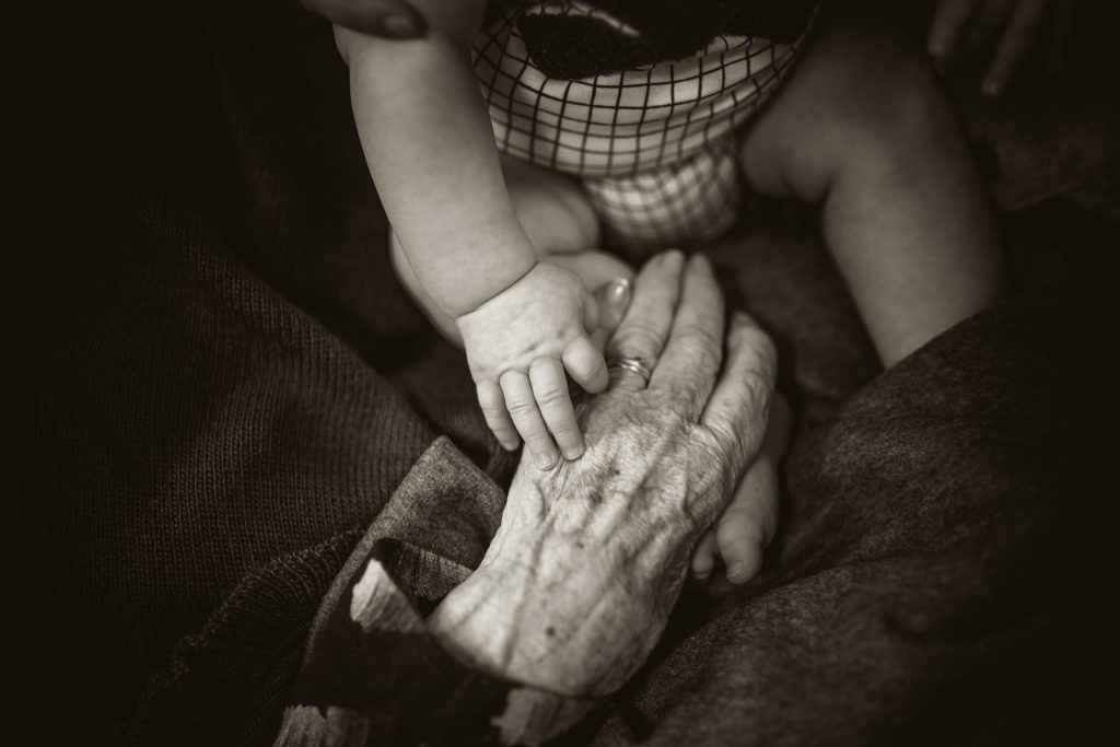 old hand holding a baby hand
