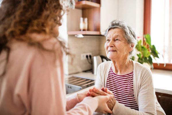 Elderly woman holding hands with daughter