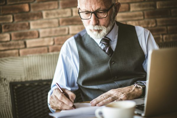 Elderly man signing documents