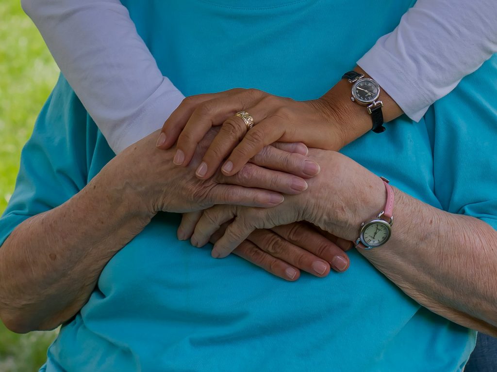 Elderly man holding hands with daughter